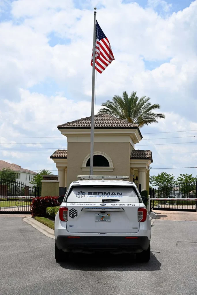 Berman vehicle in front of gate with an american flag