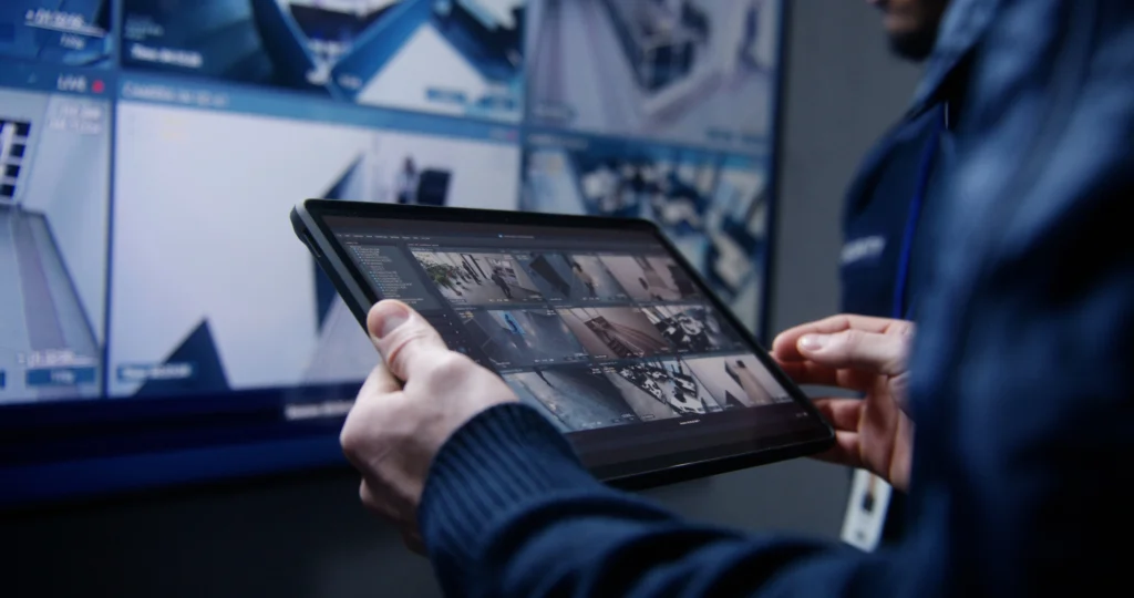 Person holding a tablet reviewing security footage